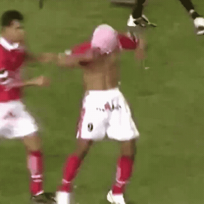 A Shirtless Soccer Player Is Being Tackled By Another Soccer Player GIF
