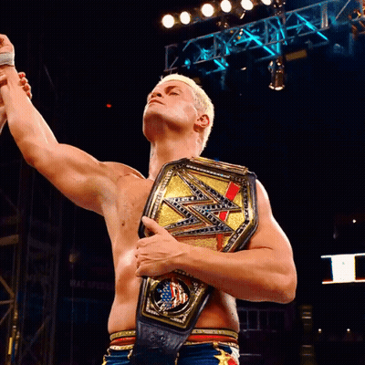 A Shirtless Wrestler Holds Up His Arms While Holding A Wwe Championship Belt GIF