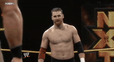 A Shirtless Wrestler In A Wrestling Ring With A N On The Back GIF