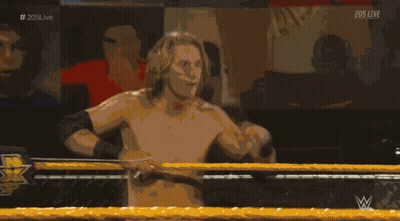 A Shirtless Wrestler In A Wrestling Ring With The Hashtag # 205Live On The Bottom GIF