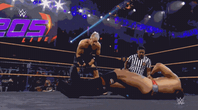 A Shirtless Wrestler In A Wrestling Ring With The Hashtag # 205Live On The Screen GIF