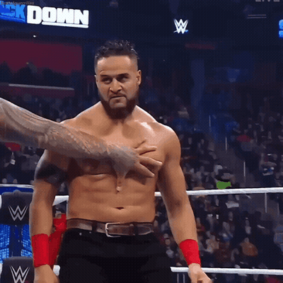 A Shirtless Wrestler Is Being Held By Another Wrestler In A Ring GIF
