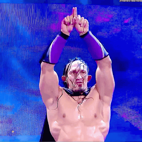 A Shirtless Wrestler Is Giving The Middle Finger While Wearing Purple Gloves GIF