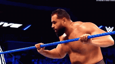 A Shirtless Wrestler Is Holding A Blue Rope In A Ring . GIF