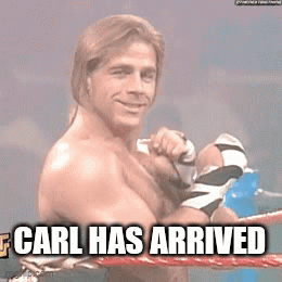 A Shirtless Wrestler Is In A Boxing Ring With The Words `` Carl Has Arrived '' Written On It . GIF