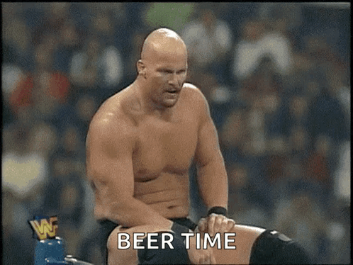 A Shirtless Wrestler Is Sitting In A Ring With The Words Beer Time Written Below Him GIF