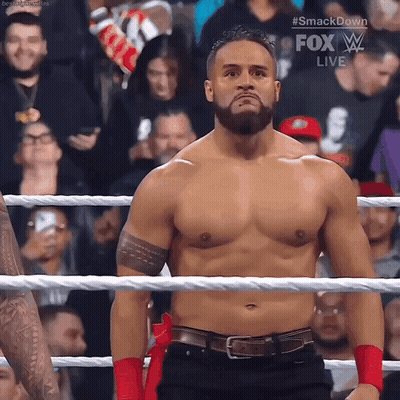 A Shirtless Wrestler Is Standing In A Ring With A Fox Live Advertisement Behind Him GIF