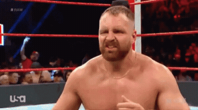 A Shirtless Wrestler Is Standing In A Wrestling Ring With A Usa Logo Behind Him GIF