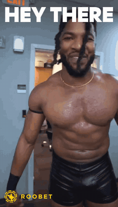 A Shirtless Wrestler Is Standing In Front Of A Door With The Words Hey There Above Him GIF