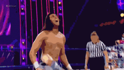 A Shirtless Wrestler Stands In A Ring With A Referee And The Hashtag # 205Live On The Bottom GIF