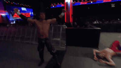 A Shirtless Wrestler Stands In A Wrestling Ring Watching Another Wrestler GIF