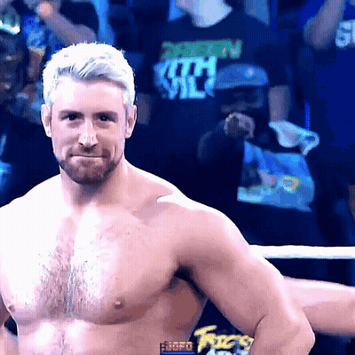 A Shirtless Wrestler Stands In Front Of A Crowd Wearing A Shirt That Says ' Shawn Michaels ' On It GIF