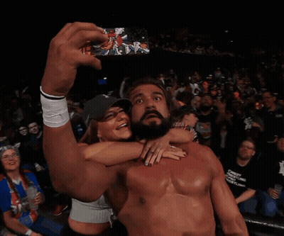 A Shirtless Wrestler Takes A Selfie With A Fan In The Crowd GIF