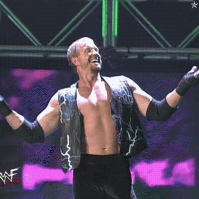 A Shirtless Wrestler Wearing A Vest That Says ' Pun ' On It GIF