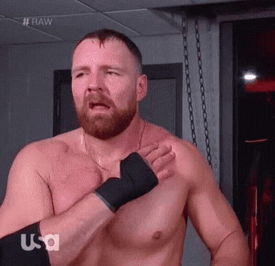 A Shirtless Wrestler With A Beard Is Standing In A Room With His Hands On His Chest . GIF