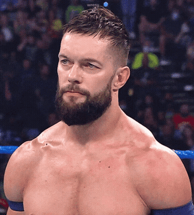 A Shirtless Wrestler With A Beard Stands In A Ring GIF