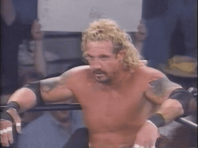 A Shirtless Wrestler With Blonde Hair And Tattoos Is Standing In A Ring . GIF