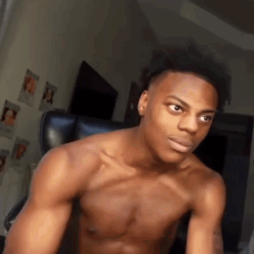 A Shirtless Young Man Is Sitting In A Chair . GIF