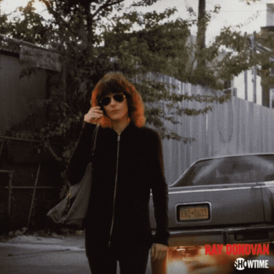 A Showtime Ad For Ray Donovan Features A Woman Talking On A Cell Phone GIF