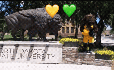 A Sign For North Dakota State University With A Statue In The Background GIF