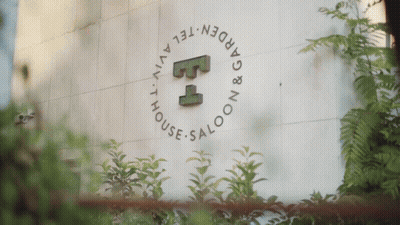 A Sign For The Garden Tel Aviv House Saloon Is Surrounded By Plants GIF