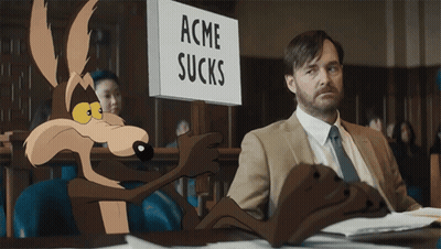 A Sign That Says Acme Sucks Next To A Man In A Suit GIF