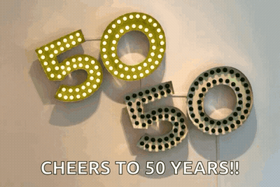 A Sign That Says Cheers To 50 Years Is Hanging On A Wall GIF