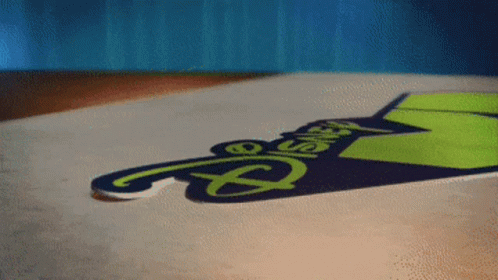 A Sign That Says Disney On It Is Laying On The Ground GIF