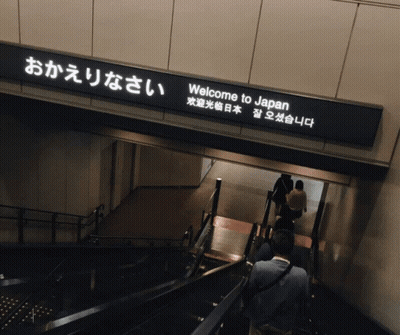 A Sign That Says Welcome To Japan Is Above A Set Of Stairs GIF