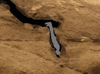 A Silhouette Of A Bat Is Flying Over A Rocky Area GIF