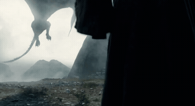 A Silhouette Of A Dragon Flying In The Air GIF