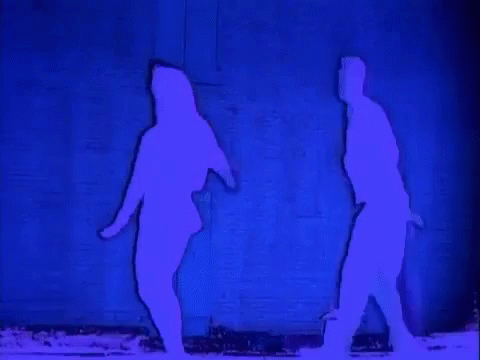 A Silhouette Of A Man And A Woman Dancing In Front Of A Blue Wall . GIF
