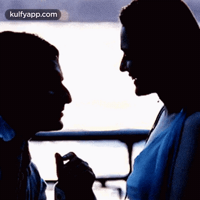 A Silhouette Of A Man And A Woman Looking At Each Other With A Kulfyapp.com Logo In The Corner GIF