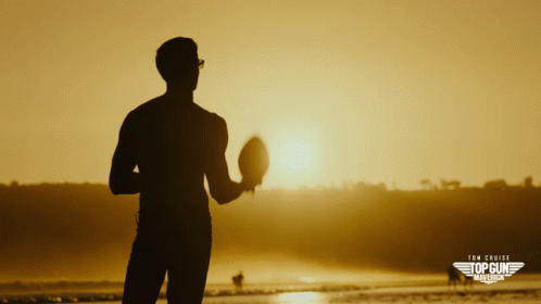 A Silhouette Of A Man Holding A Football In Front Of The Sun With The Words Tom Cruise Top Gun Marina On The Bottom Righ GIF