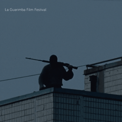 A Silhouette Of A Man Holding A Gun With La Guarimba Film Festival Written On The Bottom Right GIF