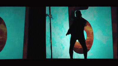 A Silhouette Of A Man Is Dancing In Front Of A Large Number 5 GIF