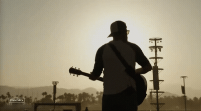 A Silhouette Of A Man Playing A Guitar With A Sign That Says ' Silhouette ' On It GIF