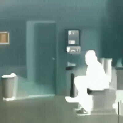 A Silhouette Of A Man Sitting On A Toilet In A Bathroom GIF
