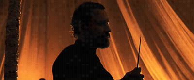 A Silhouette Of A Man With A Beard Is Holding A Wand GIF