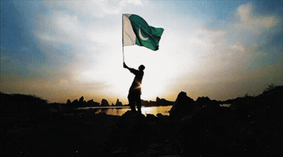 A Silhouette Of A Person Holding A Flag In Front Of A Lake GIF