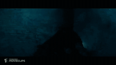 A Silhouette Of A Person In A Dark Room With A Light Coming Out Of The Ceiling . GIF