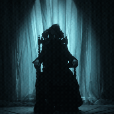 A Silhouette Of A Person Sitting In A Dark Room GIF