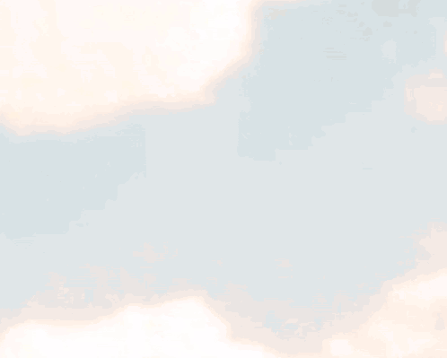 A Silhouette Of A Person Standing In Front Of A Cloudy Sky . GIF