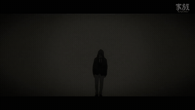 A Silhouette Of A Person Standing In The Dark With A Hood On . GIF