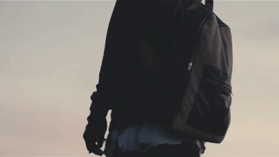 A Silhouette Of A Person Standing On Top Of A Wall With A Blue Sky In The Background GIF