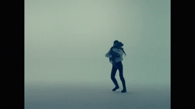 A Silhouette Of A Person With A Backpack Standing In The Fog GIF
