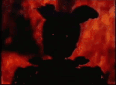 A Silhouette Of A Rabbit Is Standing In Front Of A Fire In A Dark Room . GIF