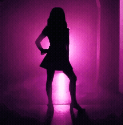 A Silhouette Of A Woman Is Dancing In Front Of A Pink Light GIF