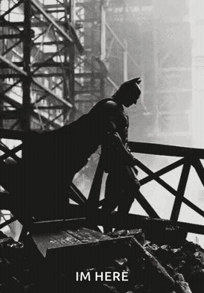 A Silhouette Of Batman Leaning On A Railing With The Words Im Here Written Below Him GIF