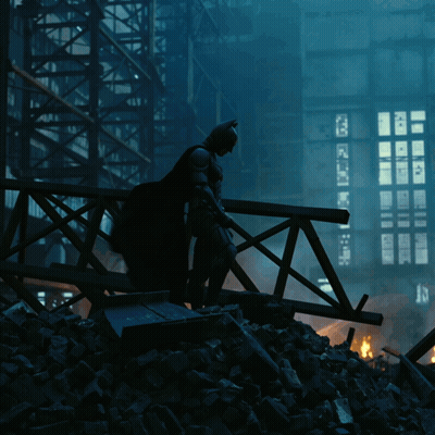 A Silhouette Of Batman Standing On A Bridge With A Building In The Background GIF